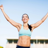 Happy female athlete posing after a victory on racing track